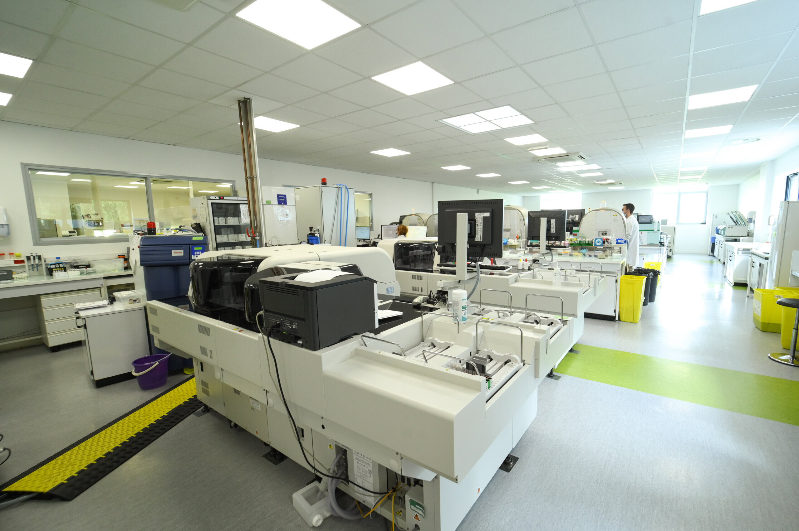 Intérieur moderne du Laboratoire Rethel Bio Ard'Aisne avec divers équipements de haute technologie et un scientifique travaillant en arrière-plan.