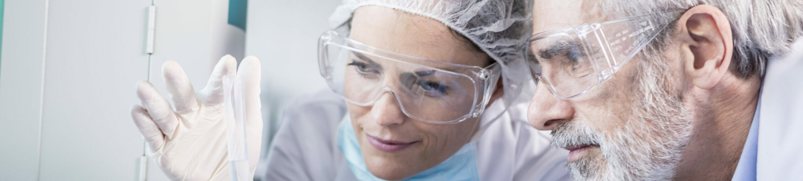 Deux scientifiques en blouse et lunettes de sécurité examinant une éprouvette au Laboratoire Bio Ard'Aisne.